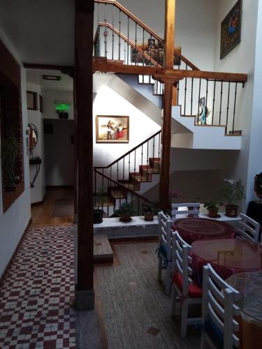 a room with a staircase and a table with chairs at Hotel Casa Ecuatreasures Centro Historico in Quito