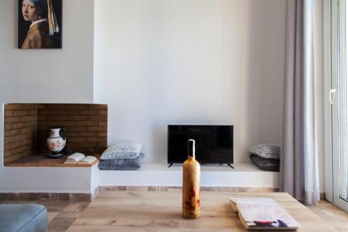 a living room with a fireplace and a bottle on a table at Ble on Blue in Athanion