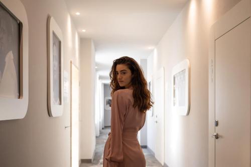 a woman in a dress walking down a hallway at Ausonia Hungaria Wellness & Lifestyle in Venice-Lido