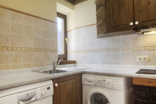 eine Küche mit einer Spüle und einer Waschmaschine in der Unterkunft Casa Banhs de Tredòs by Totiaran in Tredós