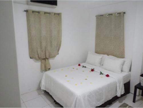 a bedroom with a white bed with roses on it at Caribbean Dream Vacation Property CD2 in Rodney Bay Village