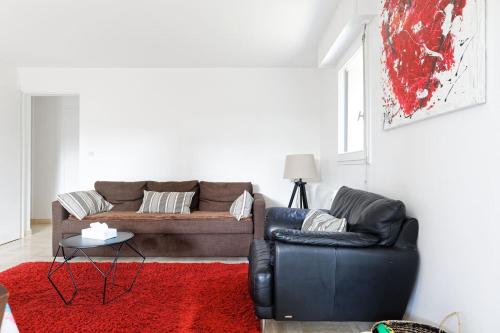 un salon avec un canapé et un tapis rouge dans l'établissement Charmant 3 pièces avec jardin à 5mn de la plage, à Deauville