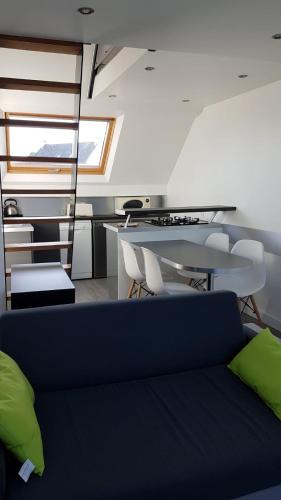 a living room with a couch and a table at Abri du pêcheur in Étel