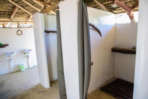 a bathroom with two sinks and a surfboard in a room at Maji Moto Maasai Cultural Camp in Narok