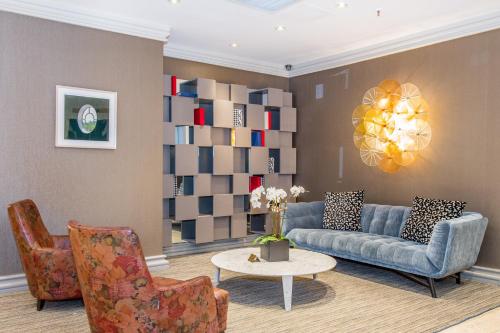 a living room with a couch and a table and chairs at Lombardy Hotel in New York