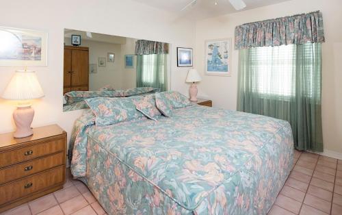 um quarto com uma cama e uma cómoda com um candeeiro em Sunswept 701 Condo em Orange Beach