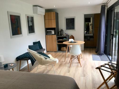 un salon avec un lit, une table et des chaises dans l'établissement Un petit nid dans la verdure, à Holtzwihr