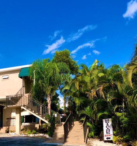 a building on the beach with palm trees at Tio Pepe’s Guest House in Aibonito