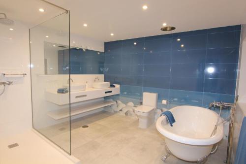 a bathroom with a tub and a sink and a toilet at Orly Club Coral Arena Dorada in Puerto del Carmen