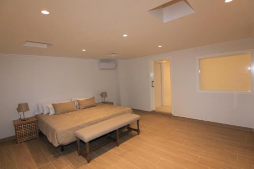 a bedroom with a bed with a bench in it at Orly Club Coral Arena Dorada in Puerto del Carmen