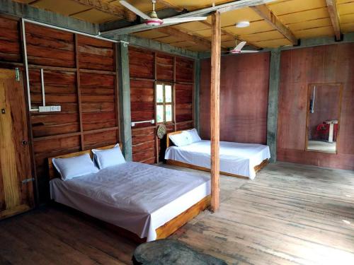 En eller flere senge i et værelse på Jungle cottage