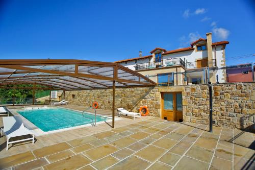 a villa with a swimming pool and a building at La Posada de Ojebar Nórdica in Rasines