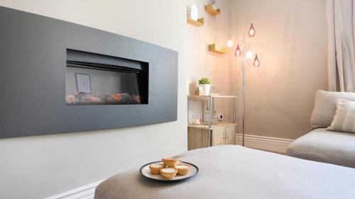 a living room with a bed and a tv on a wall at The Abbey Apartment in Hexham