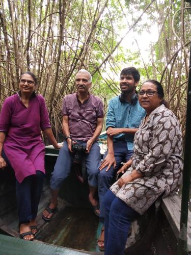 a group of people sitting on a bench in the woods at Maleyam Homestay Riverside in Kozhikode