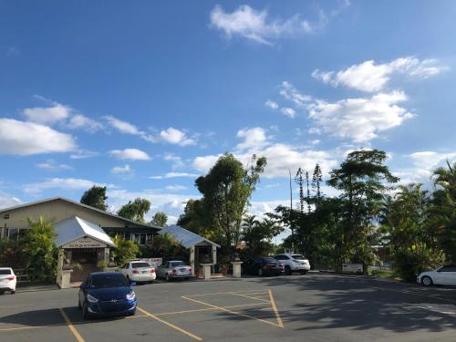 a parking lot with cars parked in front of a building at Tio Pepe’s Guest House in Aibonito