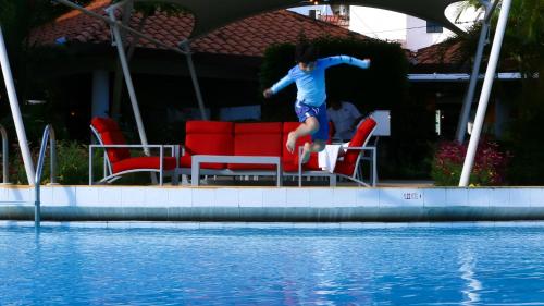 a young boy jumping into a swimming pool at Gran Hotel Nacional in David