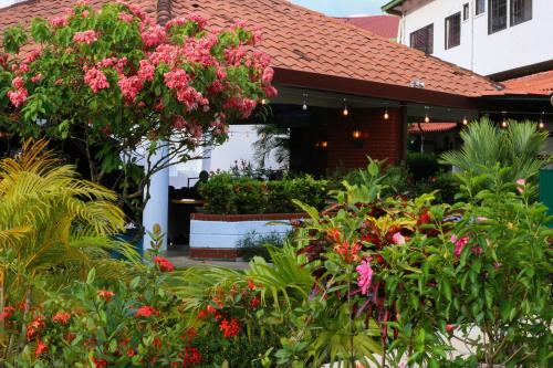 a garden in front of a building with pink flowers at Gran Hotel Nacional in David