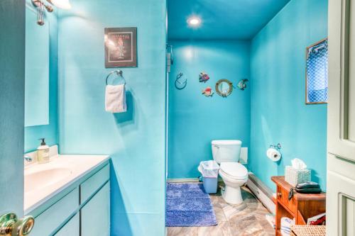 Baño azul con aseo y lavamanos en Getaway Bar on Easy Street en Rockaway Beach