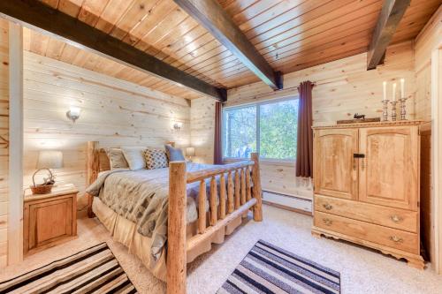 Dormitorio en cabaña de madera con cama y ventana en Welches Mt. Retreat en Welches