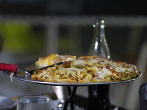 a person holding a pizza on a tray at Gran Hotel Nacional in David