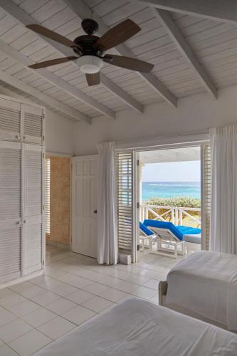 a bedroom with a bed and a ceiling fan at Inchcape Seaside Villas in Christ Church
