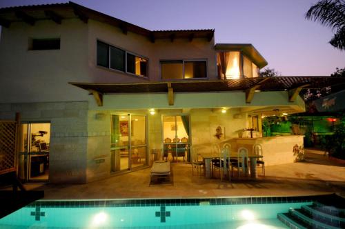 une maison avec une piscine en face de celle-ci dans l'établissement Thai villa eilat - וילה תאי אילת, à Eilat