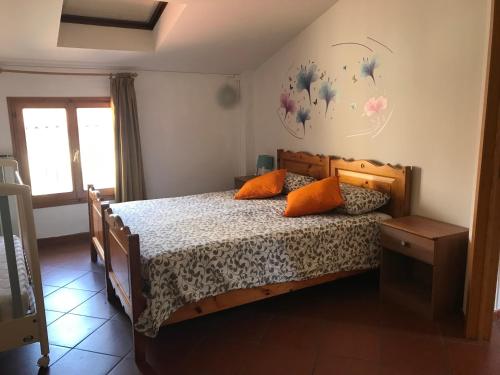 une chambre avec un lit en bois avec deux oreillers orange dans l'établissement SediciBis, à Bologne