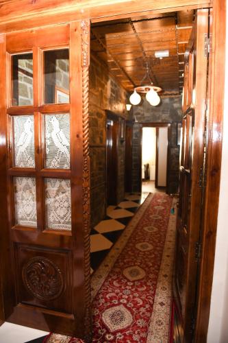 a hallway with wooden doors and a rug on the floor at Hotel Kaceli in Berat