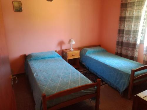 a room with two beds and a table with a lamp at Casa Marian in Federación