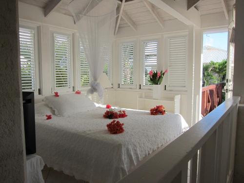 a bedroom with a white bed with red flowers on it at Inchcape Seaside Villas in Christ Church