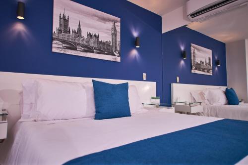 a bedroom with a large bed with blue walls at Casa Esmeralda Hotel Boutique in Cali