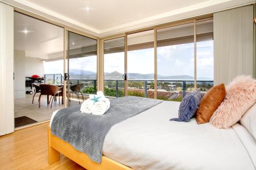 a bedroom with a large bed with a large window at Getaway Ocean Views in Airlie Beach