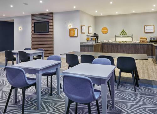 a waiting room with tables and chairs and a counter at Holiday Inn Express Grimsby by IHG in Grimsby