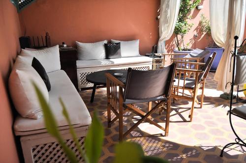 a living room with chairs and a couch and a table at Riad Inaka in Marrakech
