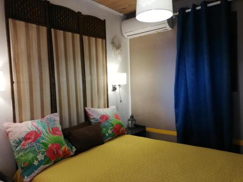 a bedroom with a bed and a blue curtain at Vanille Lodge in Le Marin