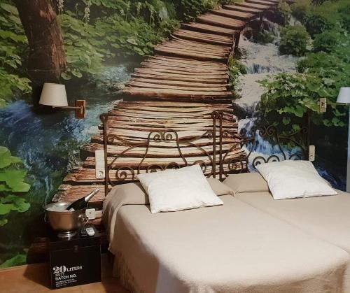 ein Schlafzimmer mit einem Bett und einem Gemälde einer Holzbrücke in der Unterkunft Hotel Iris La Eliana in L'Eliana