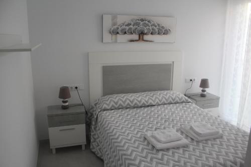 um quarto com uma cama com duas toalhas em Apartamento Iceberg Tarifa Parking gratuito em Tarifa
