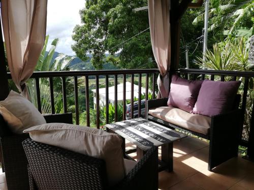 a balcony with chairs and a table and a window at Vanille Lodge in Le Marin