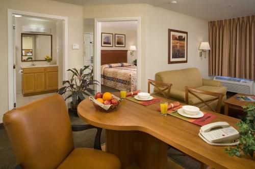 a room with a table with a bowl of fruit on it at Candlewood Suites Jacksonville by IHG in Jacksonville