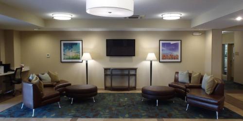 a waiting room with furniture and a flat screen tv at Candlewood Suites Pearl by IHG in Pearl