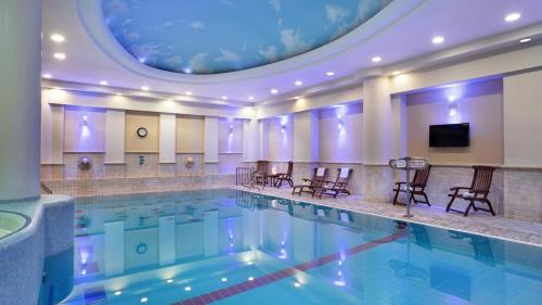 a large swimming pool with chairs and a ceiling at Crowne Plaza Haifa, an IHG Hotel in Haifa