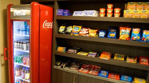 a red refrigerator sitting next to a shelf of food at Holiday Inn Express Hotel & Suites Waller by IHG in Waller