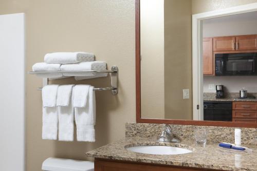 La salle de bains est pourvue d'un lavabo, d'un miroir et de serviettes. dans l'établissement Candlewood Suites La Crosse, an IHG Hotel, à La Crosse