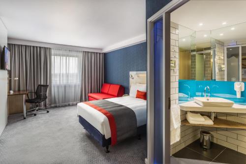 a hotel room with a bed and a bathroom at Holiday Inn Express London - Watford Junction by IHG in Watford