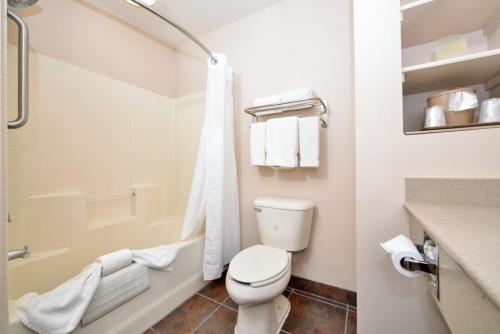 a white bathroom with a toilet and a bath tub at Holiday Inn Express Kingman, an IHG Hotel in Kingman