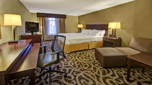 a hotel room with a bed and a television at Murfreesboro Central Hotel in Murfreesboro