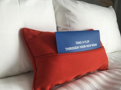 a blue sign on a red pillow on a bed at Holiday Inn Express St. Albans - M25, Jct.22 in Saint Albans