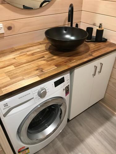 a bowl on top of a washing machine in a kitchen at Aroha Anchor Apartment in Motueka