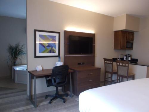 a hotel room with a bed and a desk with a television at Route 66 inn & Suites in Miami