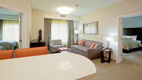 a hotel room with a living room with a couch and a bed at Staybridge Suites - Johnson City by IHG in Johnson City